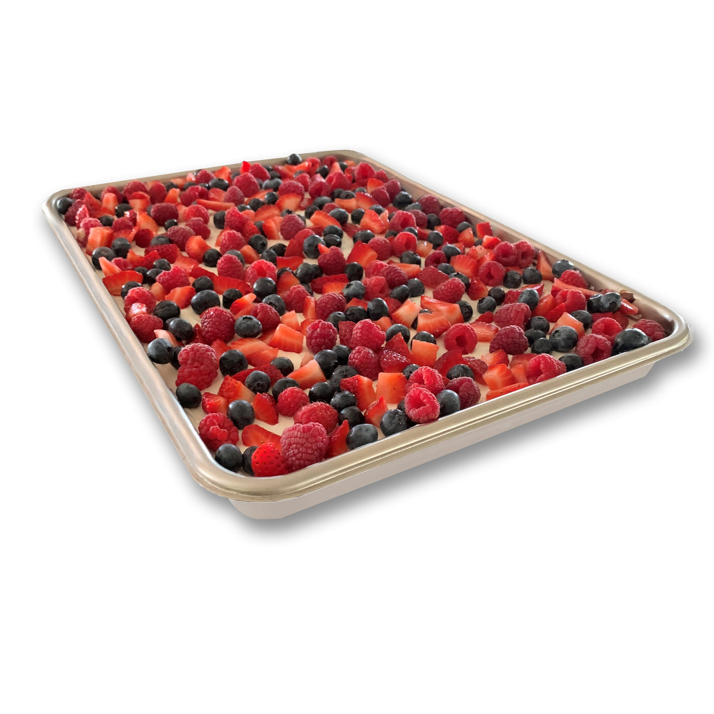 Sheet pan with a layer of white sauce topped with a variety of berries on a white background