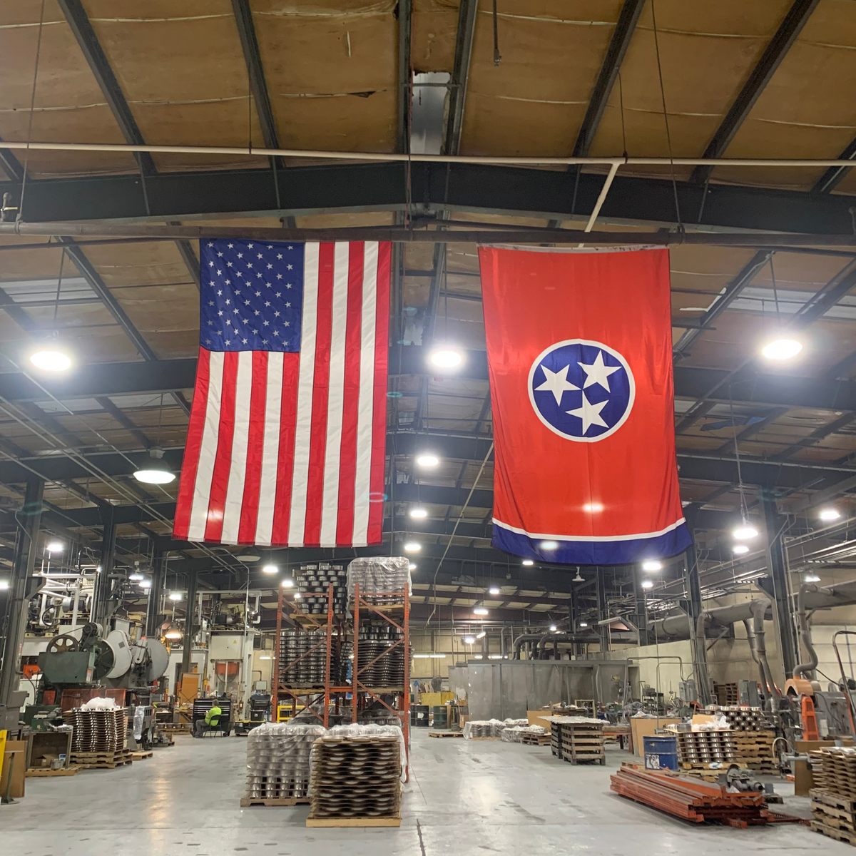 Two flags, one American and one Tennessee, hanging in a warehouse.